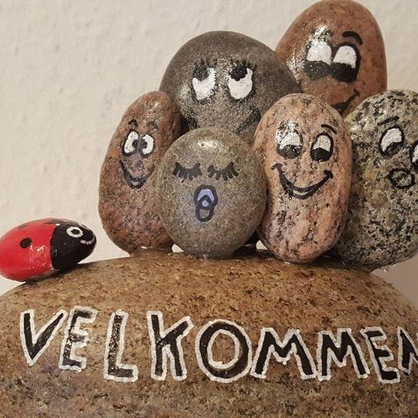 Sten med ansigter og velkommen skrevet på