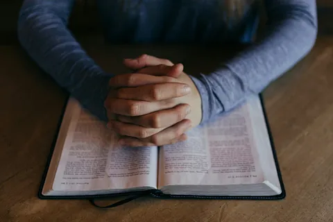 Foldede hænder og bibel
